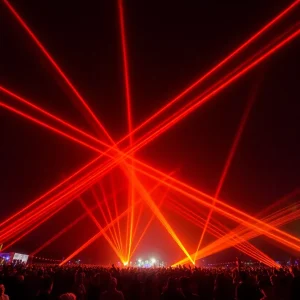 Orange laser display lighting up the sky at Stillwater during an entertainment event.