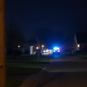 Police lights in a Tulsa neighborhood after a tragic incident.